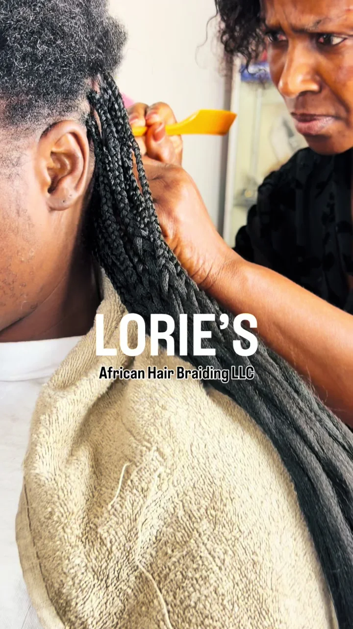 Stylist braiding a client’s hair at Lorie’s salon in Hartford